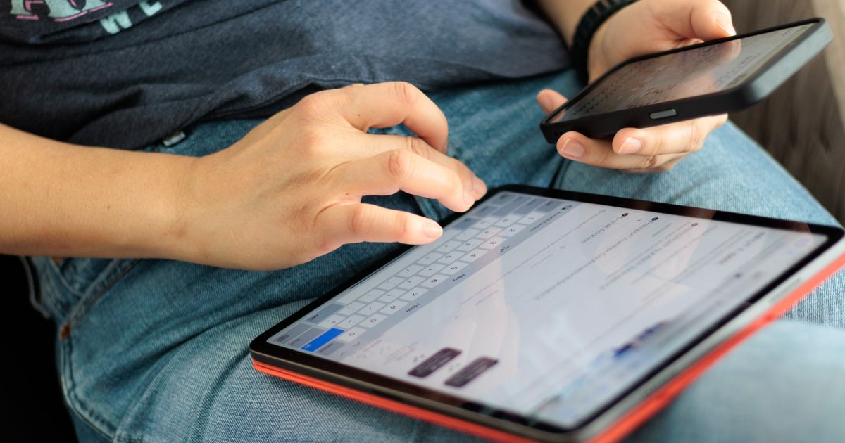 タブレットとスマホを操作する手元